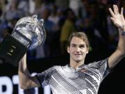 Switzerland's Roger Federer waves while he does a lap of honor with his trophy after defeating Spain's Rafael Nadal in the men's singles final at the Australian Open tennis championships in Melbourne, Australia, Sunday, Jan. 29, 2017.