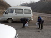 A villager surnamed Shen, left and another fellow villager pick up pieces of coal that fell from overfilled coal trucks tumbling down an uneven junction near the Shougang steel factory in Qianan in northern China&#039;s Hebei province. Across vast swathes of northern China, particularly in the poor countryside, residents still go to great lengths to acquire and burn coal for warmth despite government efforts to ban the practice and introduce cleaner, but costlier, types of coal or electrical heating.