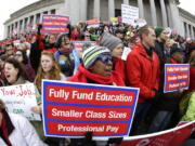 Oveta Hunter, center, who has been an elementary school teacher for more than 30 years and currently teaches at Hawthorne Elementary in Seattle, cheers and holds a sign Monday during a rally in support of education funding at the Capitol in Olympia, Wash. Lawmakers in the current legislative session are working to comply with a 2012 Washington Supreme Court ruling that mandates fully funding the state&#039;s basic education system. (AP Photo/Ted S.