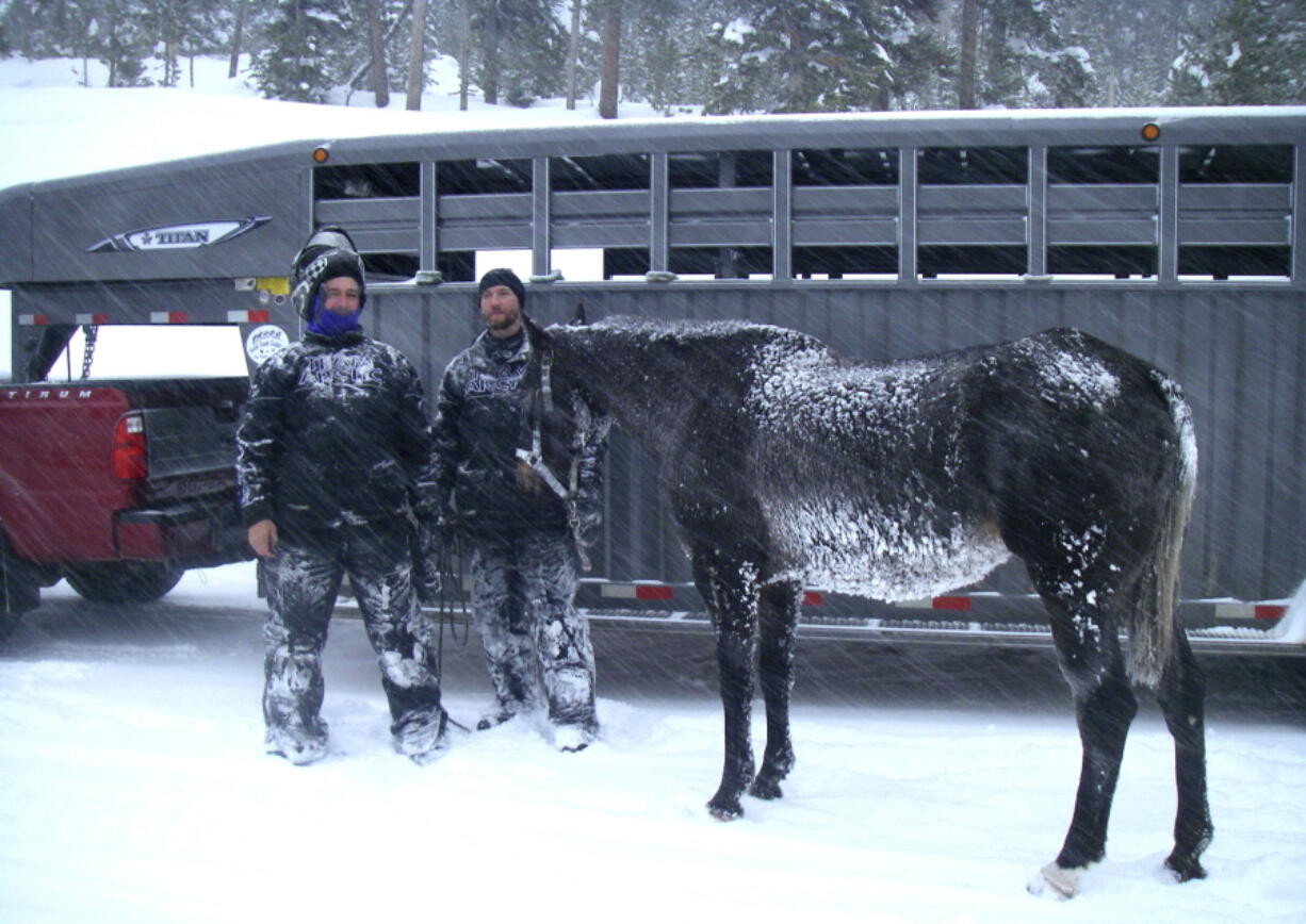 B.J. Hill and his son, Heath, from Swift Creek Outfitters stand with their horse, Valentine, in December after rescuing it from a remote area in northwestern Wyoming. The horse was left behind in the Wyoming wilderness by an excursion company after getting sick but it survived for six weeks and was healthy when she was found. (U.S.