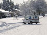 A mailman navigates snowy streets in Northwest Vancouver near Franklin Park on Friday.