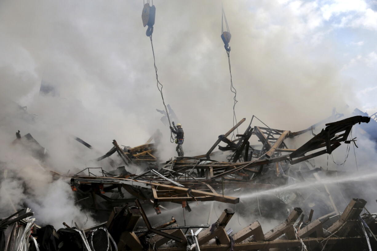 An Iranian firefighter works at the scene of the Plasco building which was engulfed by a fire and collapsed on Thursday, in central Tehran, Iran, Friday, Jan. 20, 2017. Scores of workers and dozens of trucks were searching the ruins Friday, a day after a historic high-rise building in the heart of Tehran caught fire and later collapsed.