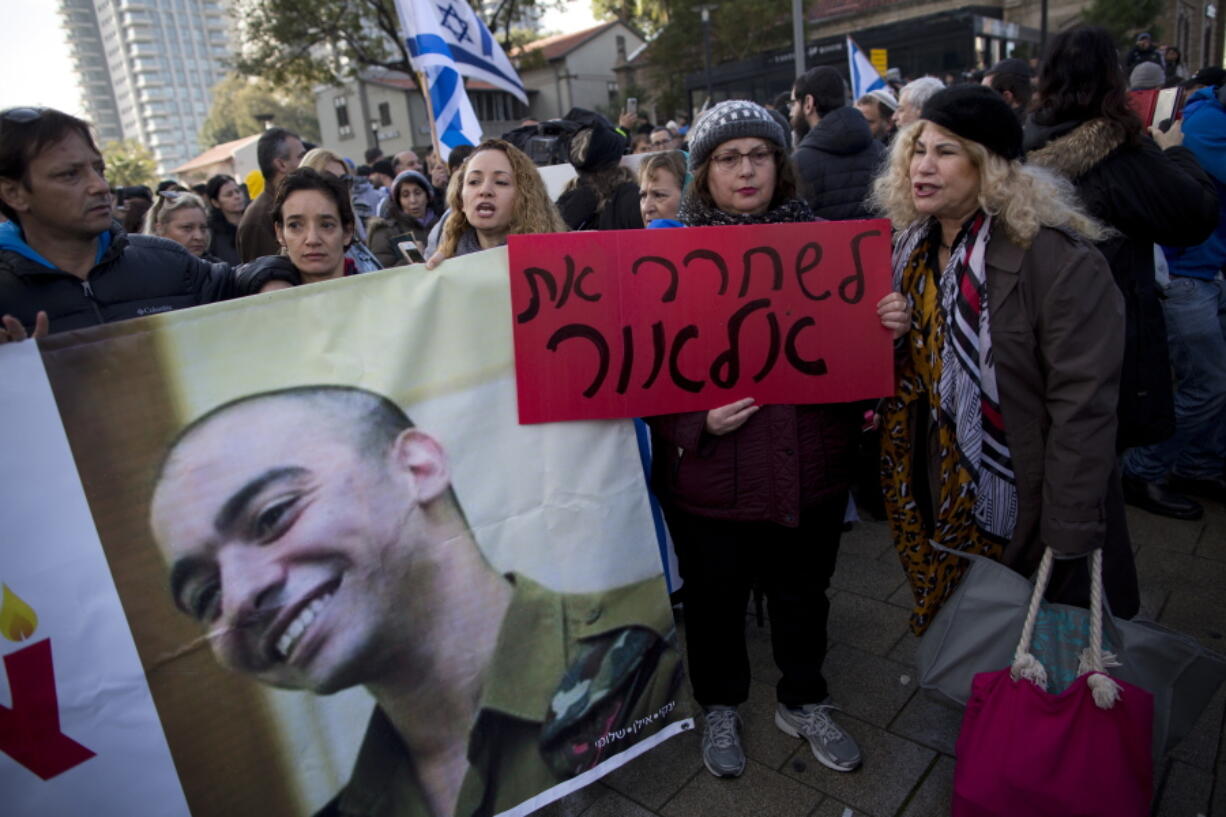 Hard-line nationalist supporters of Israeli army medic Sgt. Elor Azaria hold his photo and shout slogans Wednesday outside the Israeli military court in Tel Aviv, Israel.