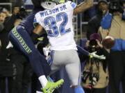 Seattle Seahawks wide receiver Paul Richardson, left, reaches around Detroit Lions strong safety Tavon Wilson (32) to make a catch for a touchdown in the first half of an NFL football NFC wild card playoff game, Saturday, Jan. 7, 2017, in Seattle.