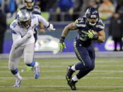 Seattle Seahawks running back Thomas Rawls, right, rushes as he is pursued by Detroit Lions defensive end Ezekiel Ansah (94) in the first half of an NFL football NFC wild card playoff game, Saturday, Jan. 7, 2017, in Seattle.