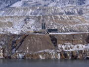 Tthe Horseshoe Bend Treatment Plant is seen at the far shore of the Berkeley Pit in Butte, Mont. Federal officials plan to pump the toxic water into the plant starting in 2023 to keep it below a critical level and prevent it from escaping the pit.