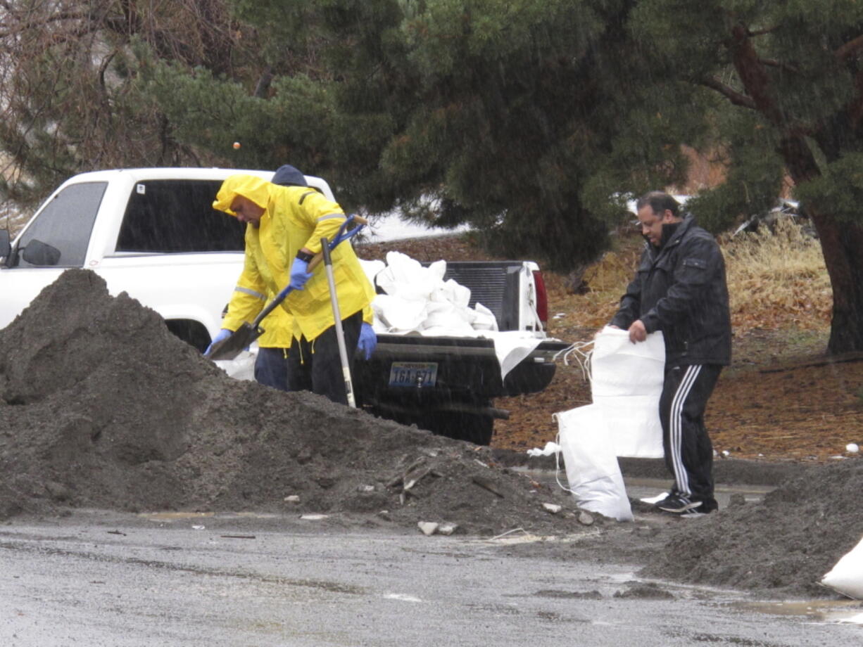 Residents fill sandbags Sunday near the Truckee River in Sparks, Nev., where streams and drainage ditches have been overflowing.