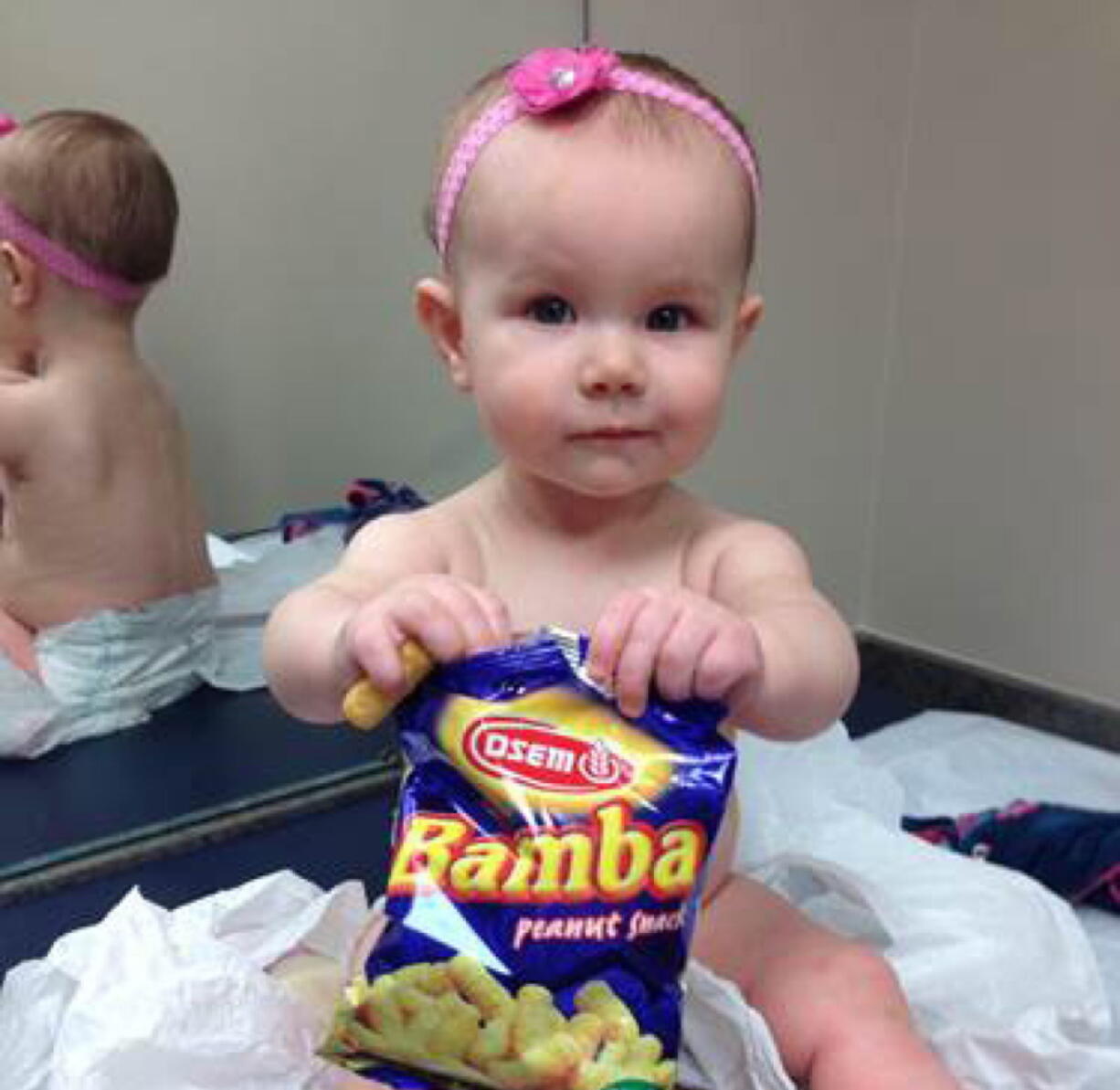 Estelle holds a bag of peanut snacks in her pediatrician&#039;s office at age 9 months in Columbus, Ohio. Most babies should start eating peanut-containing foods well before their first birthday, say guidelines released Thursday that aim to protect high-risk tots and other youngsters, too, from developing the dangerous food allergy.