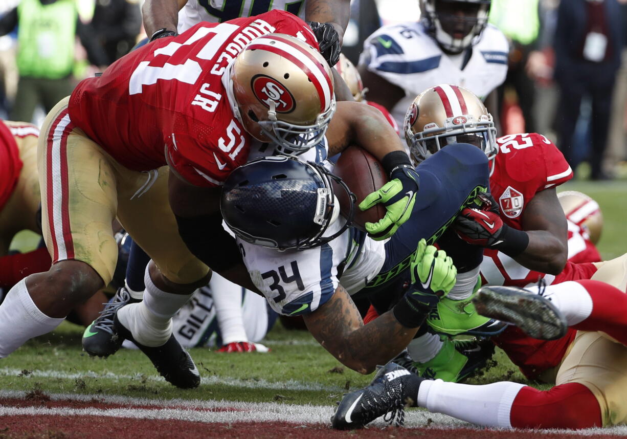 Seattle Seahawks running back Thomas Rawls (34) scores a touchdown between San Francisco 49ers middle linebacker Gerald Hodges (51) and strong safety Jaquiski Tartt (29) during the first half of an NFL football game in Santa Clara, Calif., Sunday, Jan. 1, 2017.