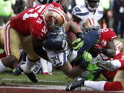 Seattle Seahawks running back Thomas Rawls (34) scores a touchdown between San Francisco 49ers middle linebacker Gerald Hodges (51) and strong safety Jaquiski Tartt (29) during the first half of an NFL football game in Santa Clara, Calif., Sunday, Jan. 1, 2017.