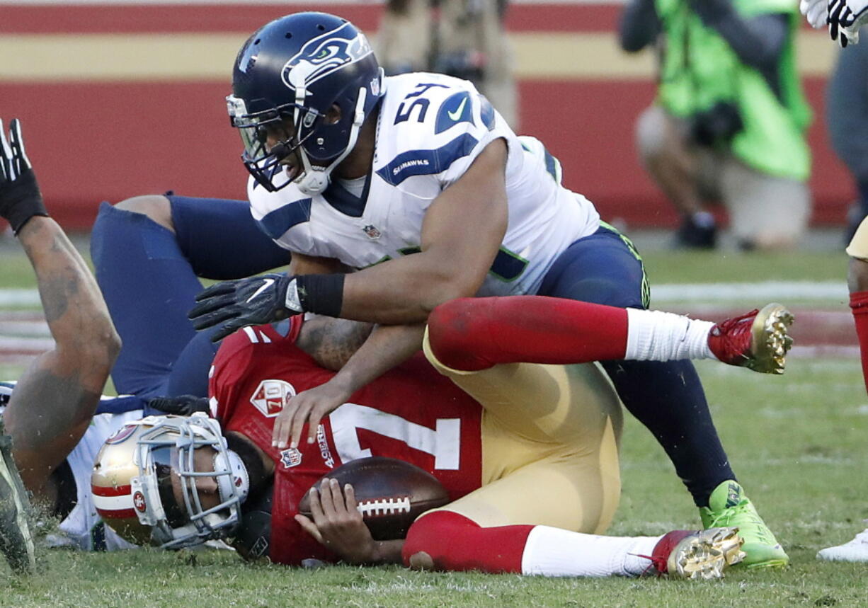 San Francisco 49ers quarterback Colin Kaepernick (7) is sacked by Seattle Seahawks middle linebacker Bobby Wagner (54) during the second half of an NFL football game in Santa Clara, Calif., Sunday, Jan. 1, 2017.