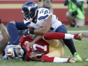 San Francisco 49ers quarterback Colin Kaepernick (7) is sacked by Seattle Seahawks middle linebacker Bobby Wagner (54) during the second half of an NFL football game in Santa Clara, Calif., Sunday, Jan. 1, 2017.