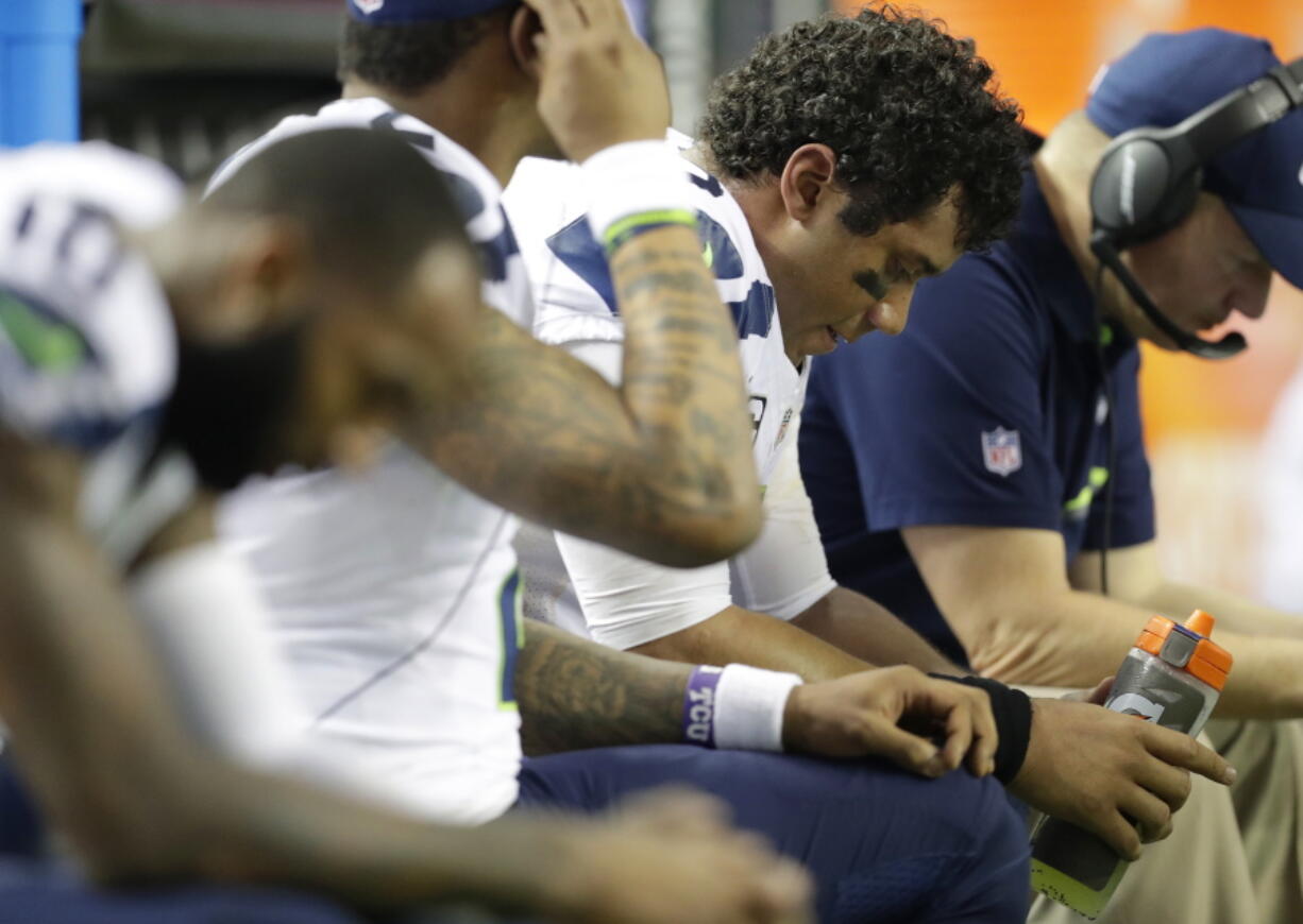 Seattle Seahawks quarterback Russell Wilson (3) sits with players on the bench during the second half of an NFL football divisional football game against the Atlanta Falcons, Saturday, Jan. 14, 2017, in Atlanta.