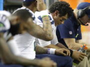 Seattle Seahawks quarterback Russell Wilson (3) sits with players on the bench during the second half of an NFL football divisional football game against the Atlanta Falcons, Saturday, Jan. 14, 2017, in Atlanta.