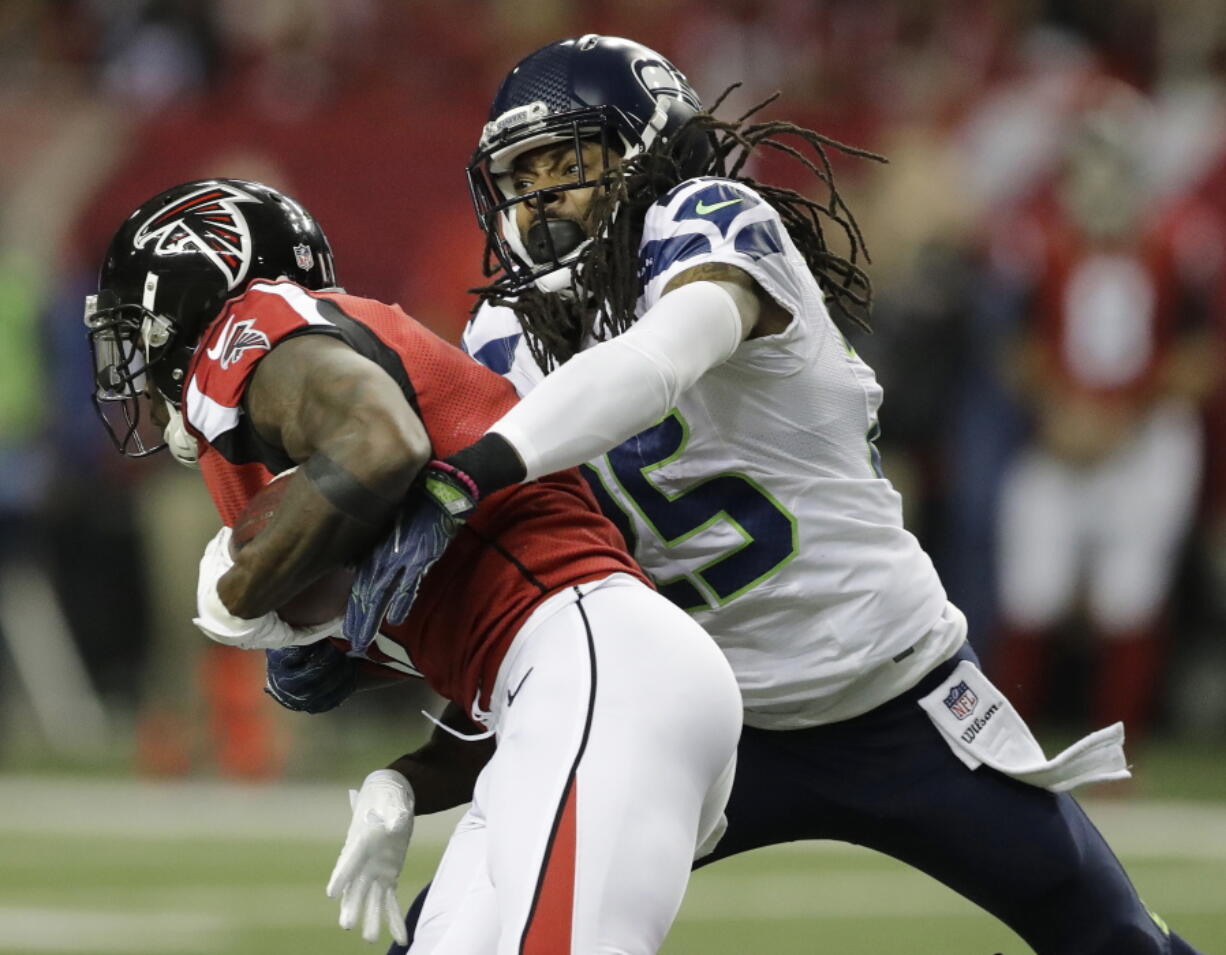 Seattle Seahawks cornerback Richard Sherman (25) tackles Atlanta Falcons wide receiver Julio Jones (11) during the first half of an NFL football NFC divisional playoff game, Saturday, Jan. 14, 2017, in Atlanta.