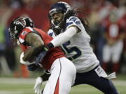 Seattle Seahawks cornerback Richard Sherman (25) tackles Atlanta Falcons wide receiver Julio Jones (11) during the first half of an NFL football NFC divisional playoff game, Saturday, Jan. 14, 2017, in Atlanta.