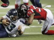 Atlanta Falcons cornerback Brian Poole (34) hits Seattle Seahawks quarterback Russell Wilson (3) during the first half of an NFL football NFC divisional playoff game, Saturday, Jan. 14, 2017, in Atlanta.