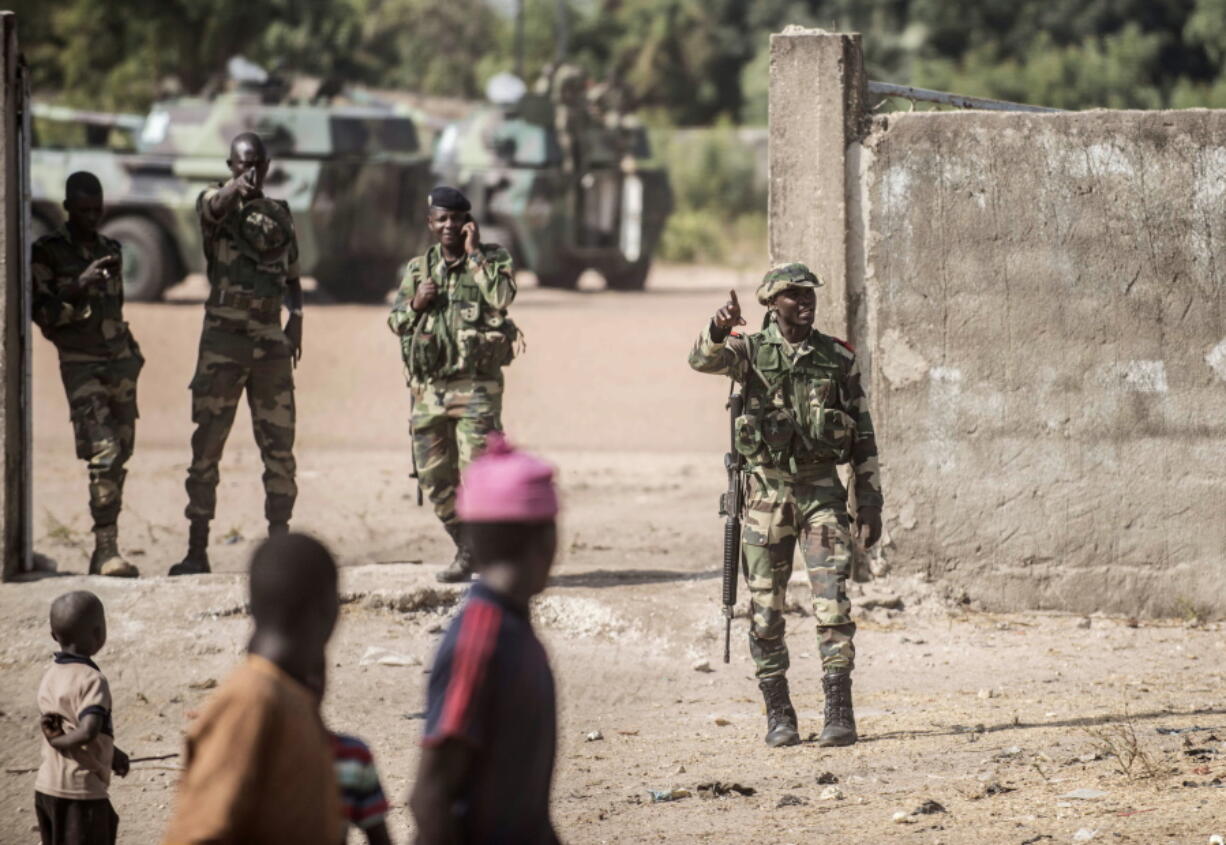 Local children watch Senegal soldiers providing security to their local gathering point at the Gambia border with Senegal at the town of Karang, Senegal, Friday, Jan. 20, 2017. Gambia&#039;s defeated President Yahya Jammeh must cede power by noon Friday or he will be dislodged by a regional force that has already moved into the country, West African officials said.