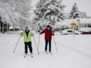 Kate Ketcham, left, and James Lanz of Vancouver take advantage of the snowy weather to do a little cross-country skiing along Northwest Daniels Street on Wednesday morning. Vancouver saw historic snowfalls, with up to a foot of powder falling in some places.