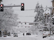 Snow hangs on power lines and stoplights as motorists and drivers navigate through downtown Vancouver on Wednesday morning, Jan. 11, 2017.