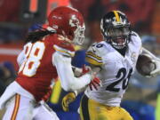 Pittsburgh running back Le&#039;Veon Bell (26) runs from Kansas City&#039;s Ron Parker (38) during the second half Sunday. Bell carried the ball 30 times for 170 yards.