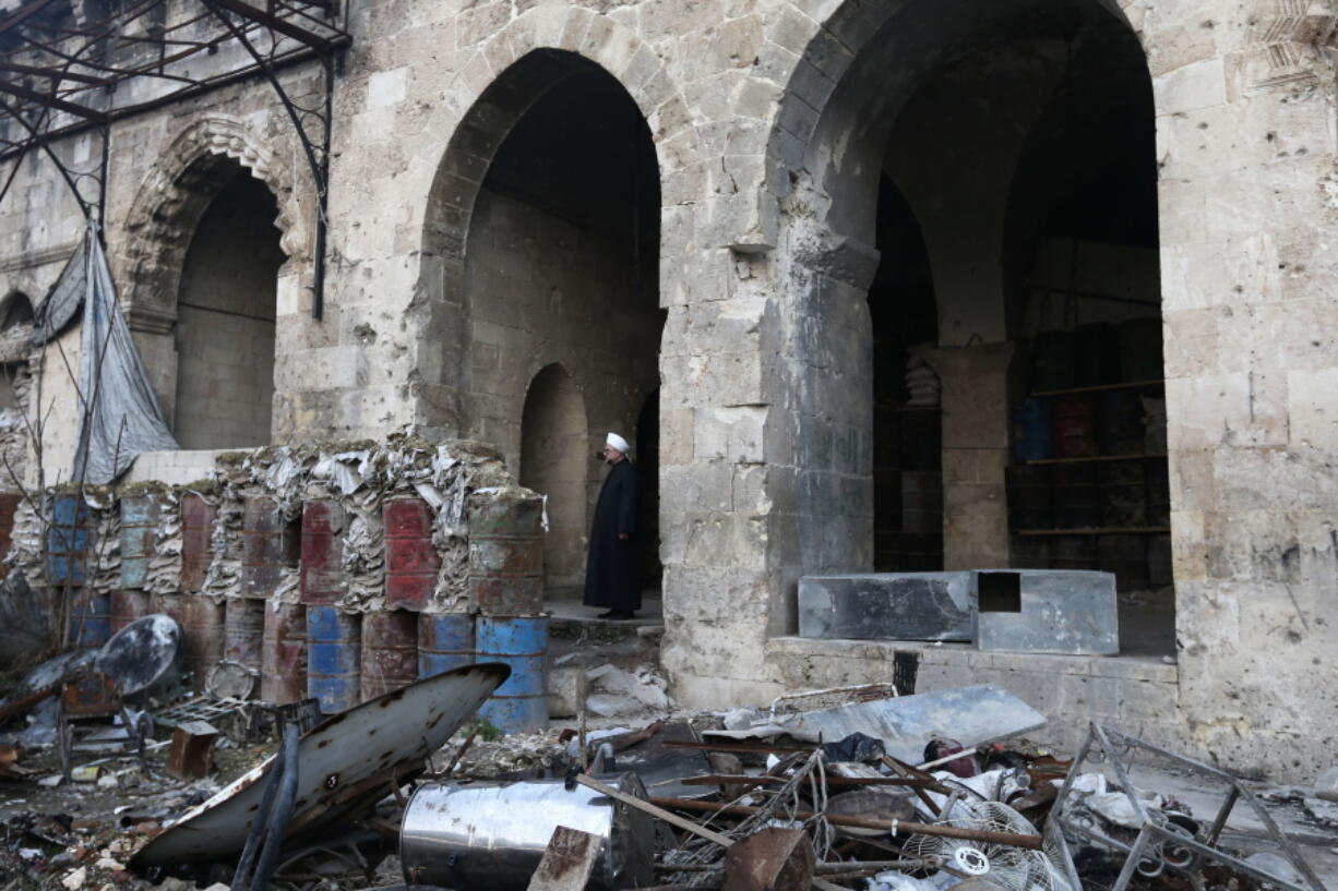 Sheikh Abdul-Qader Shehabi walks inside the heavily damaged Great Mosque of Aleppo, in the Old City of Aleppo, Syria.