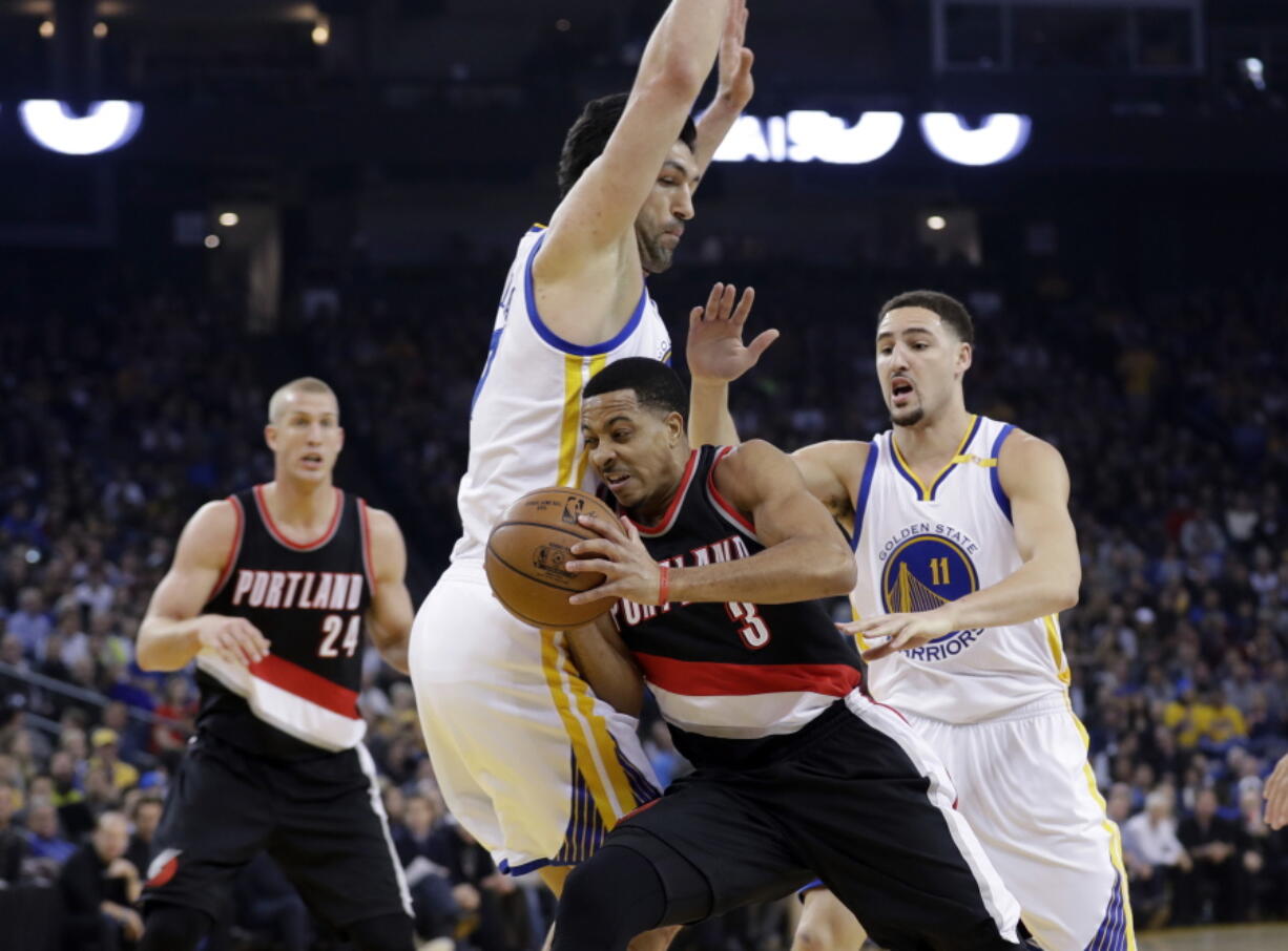 Portland Trail Blazers&#039; C.J. McCollum (3) is defended by Golden State Warriors&#039; Zaza Pachulia, center, during the first half of an NBA basketball game, Wednesday, Jan. 4, 2017, in Oakland, Calif.