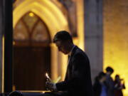 Jonathan Ryan writes a note of home as he joins other community activists in front of San Fernando Cathedral for a vigil on the eve of President-elect Donald Trump&#039;s inauguration, Thursday in San Antonio. The group gathered to show their support for immigration groups, women&#039;s groups, minorities, and others they fear may be harmed by new policies.