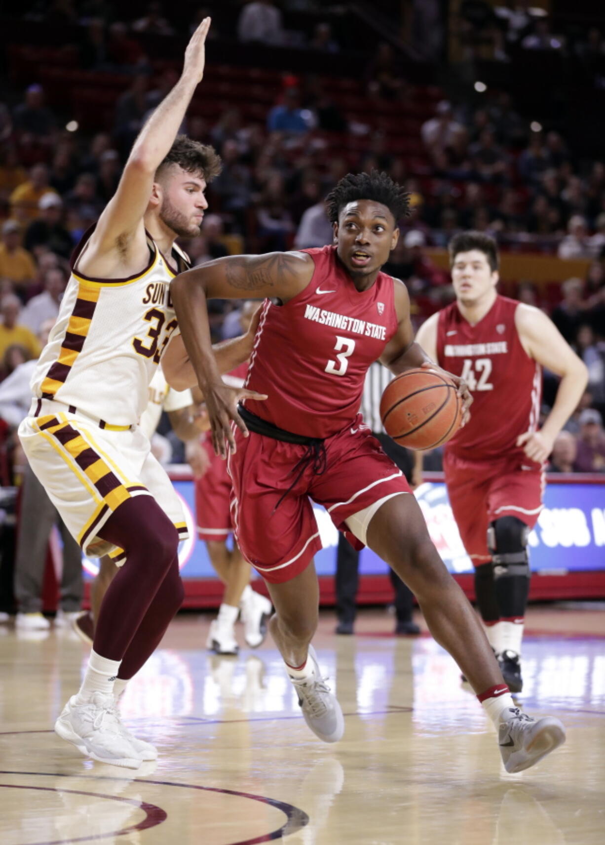 Washington State forward Robert Franks, an Evergreen High School grad, drives past Arizona State forward Ramon Vila (33) during the first half Sunday in Tempe, Ariz. Franks scored six points and made three of four field goals.