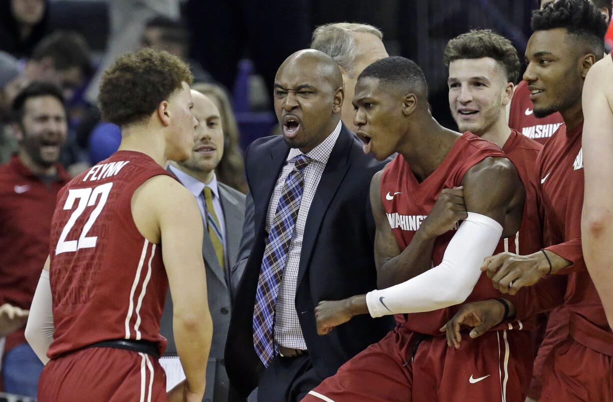 Washington State players and coaches rush to greet Malachi Flynn (22) after Flynn scored against Washington in the final moments of the second second half of an NCAA college basketball game Sunday, Jan. 1, 2017, in Seattle. Washington State won 79-74.