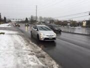 Motorists traveling on Southeast 164th Avenue drive through rain not ice, though snow remains on the sides of the road.