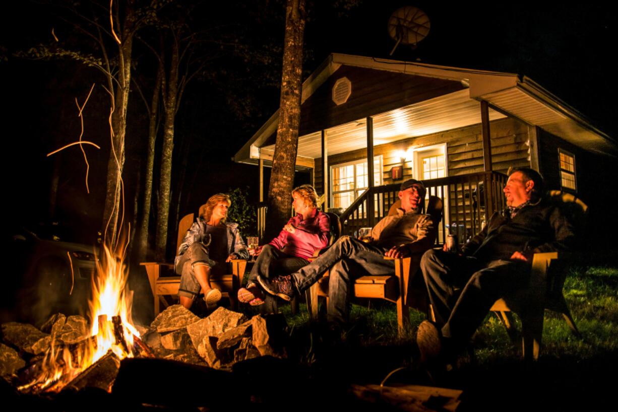 Guests enjoying a crackling fire by their cottage that overlooks the Shubenacadie River.