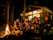 Guests enjoying a crackling fire by their cottage that overlooks the Shubenacadie River.