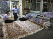 Iranian merchants wait for customers at a carpet market in 2015 in Tehran&#039;s old, main bazaar, in Iran. Bazaars such as this, along with mosques, museums and other sites, are on itineraries for sightseeing trips to Iran offered by tour companies.