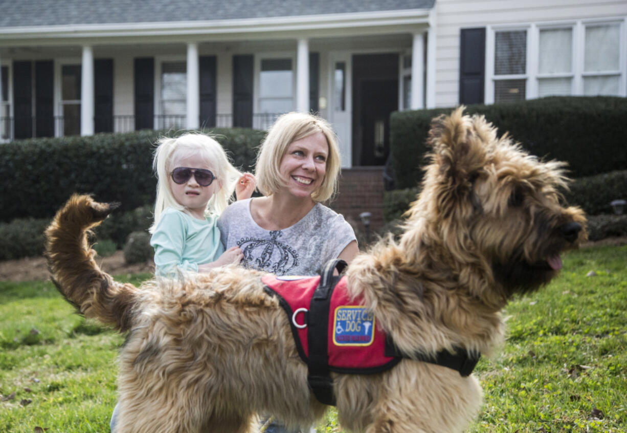 Tara Deane and her 4-year-old daughter Eliana, who has albinism and autism and is partially sighted, work with Eliana&#039;s service-dog-in-training, Butters, this month.