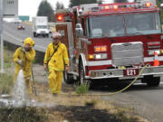 Clark County Fire &amp; Rescue firefighters help put out a series of grass fires that broke out along Interstate 5 in 2010.