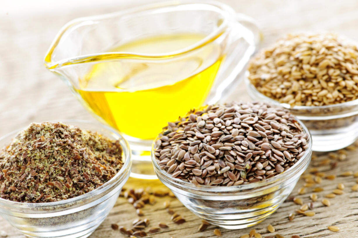 Bowls of whole and ground flax seed with linseed oil.