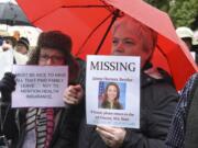 Kathy Hughes, from Chinook, left, and Karla Nelson, from Long Beach, hold up their signs at a rally outside Jaime Herrera Beutler’s office on Tuesday.