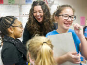 Kimberley Astle laughs with students Kaelyn Thomas, 10, left, and Siena Low, 11, while helping them with a science experiment.