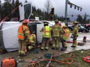 Firefighters work to cut motorists from a pickup involved in a two-vehicle crash Tuesday afternoon at Dollars Corner. The crash sent three people to the hospital with serious injuries.