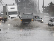 Drivers navigate standing water early this month on state Highway 503 near Northeast 87th Street in the Orchards area.