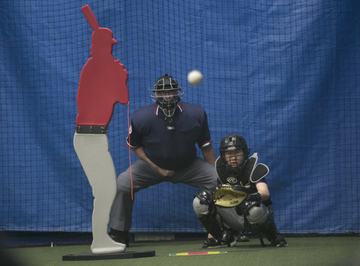 Aaron Hsu, 14  of Mountain View High School, right, practices catching a baseball at Advanced Skills Baseball in Vancouver on Monday. The business has opened its doors in the former Oxford Athletic Club.