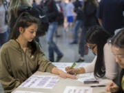 Freshman Odessa Thompson, 15, gets a henna tattoo from senior Hana Rabbani, 17, the vice-president of the Muslim Student Association, during Acceptance Week at Camas High School, in which four student organizations teamed up to create a week of educational events.