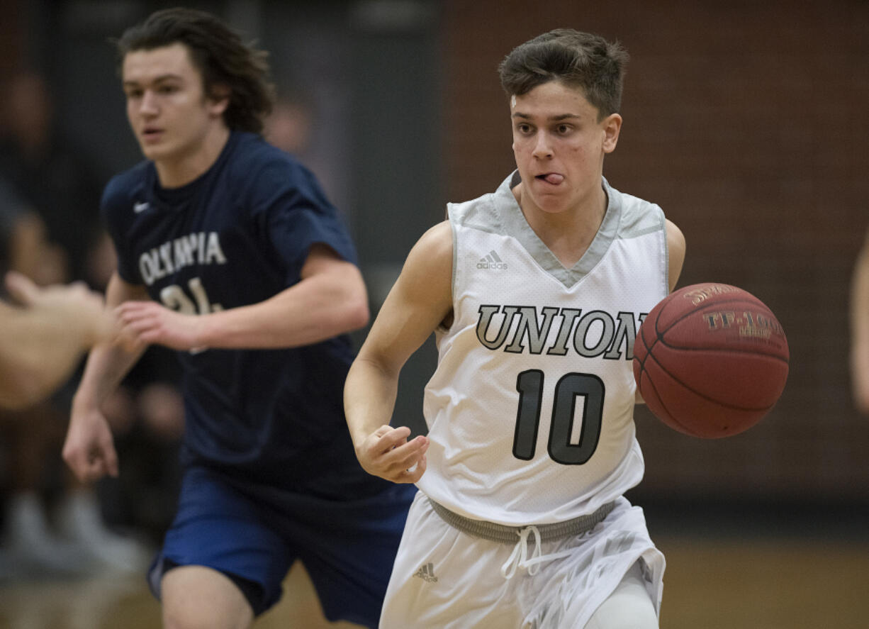 Union&#039;s Zach Reznick (10) keeps his concentration as he leads a fast break in the first quarter against Olympia at Union High School on Thursday.