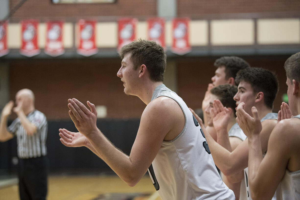 Union's Cameron Cranston, center, joins fellow players as they cheer on teammates from the bench against Olympia at Union High School on Thursday night, Feb. 9, 2017.