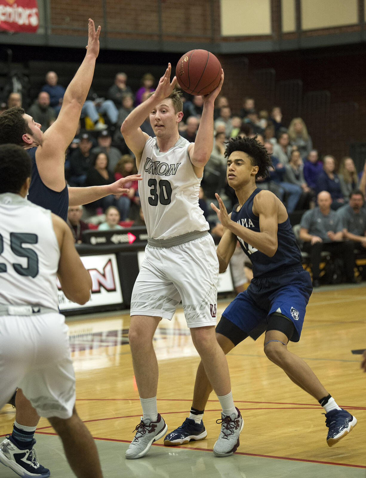 Union's Cameron Cranston (30) battles Olympia defenders in the first quarter at Union High School on Thursday night, Feb. 9, 2017.