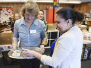 Ariane Kunze/The Columbian 
 Maria Medina, right, and Georgina Beltran try a Mexican chicken and rice soup Tuesday at the Fresh Food Pantry at Ellsworth Elementary School in Vancouver. The Family and Community Resource Center provides a Fresh Food Pantry twice a month, sometimes featuring samples of meals cooked with food from the resource center.