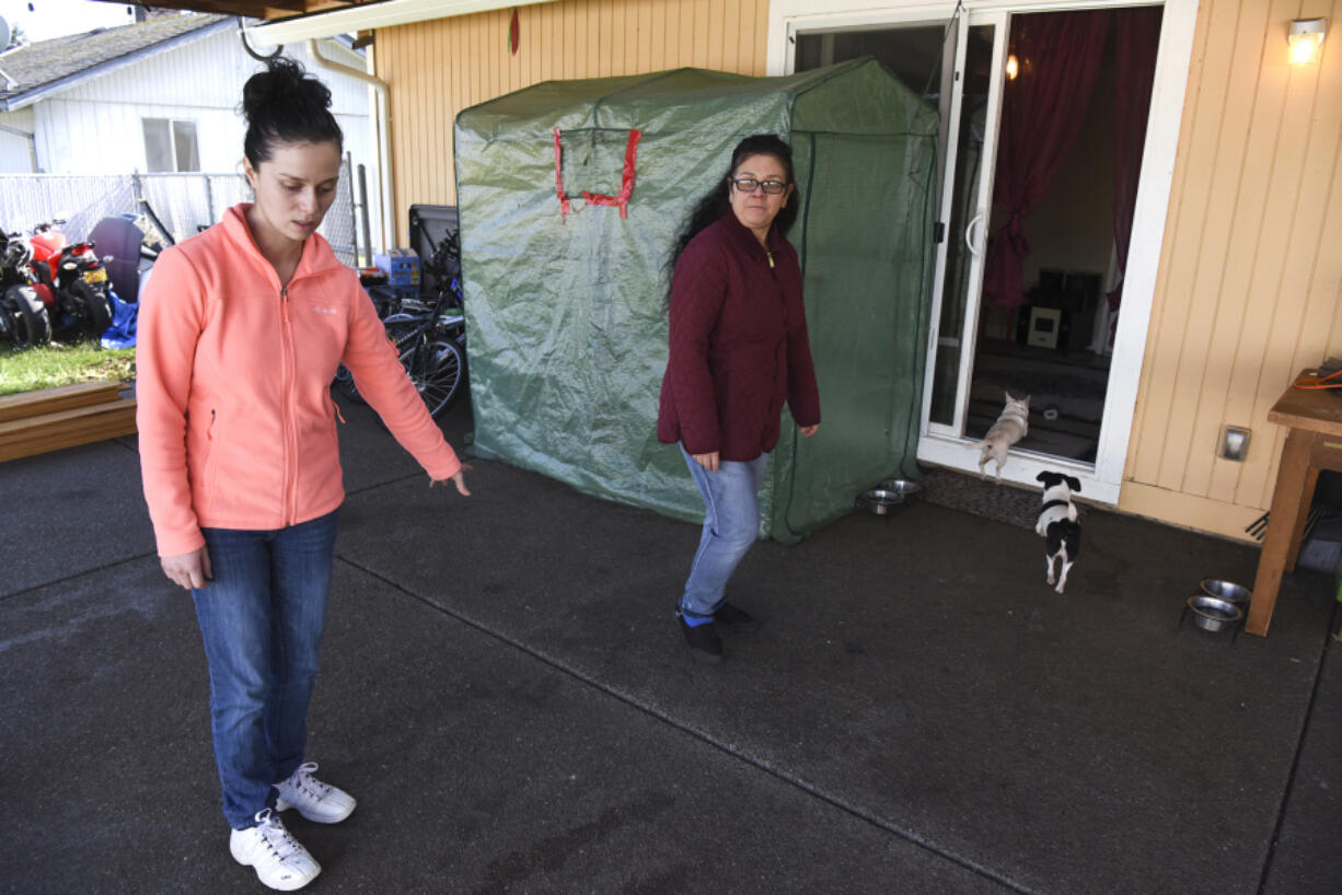 Ana Govea, left, points to the spot where Jane, a pit bull, attacked and killed Princess, her Chihuahua. Govea's mother, Maria Gonzalez, center, was home with several small children when Jane broke through the backyard gate.