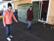 Ana Govea, left, points to the spot where Jane, a pit bull, attacked and killed Princess, her Chihuahua. Govea's mother, Maria Gonzalez, center, was home with several small children when Jane broke through the backyard gate.