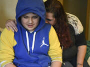 Ashly Oliver-Edwards, right, hugs her son, Mazzeo Sanchez, 12, after he recounted coming face-to-face with a man who entered their Vancouver apartment last week and armed himself with a knife. The man was later shot and killed by police. Oliver-Edwards, her four children and roommate Roger Duffey were displaced by the ordeal and are staying at a Vancouver hotel.